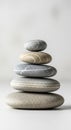 Five smooth stones are stacked in a balanced tower against a plain background. Each stone varies in Royalty Free Stock Photo