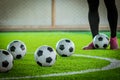 Five soccer balls with player feet