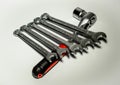 Five spanners leaned against ratchet with a red handle on a white background. Royalty Free Stock Photo