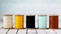 Assorted colorful threads on wooden spools, creating a collection of craft and sewing essentials on a light wooden table Royalty Free Stock Photo