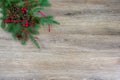 Pinecones, red berries, and a red ribbon on a spruce bough with