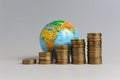 Five stacks of coins with a globe Royalty Free Stock Photo