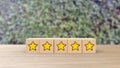 Five Star Cartoon Sketch Style on Wooden cube review blur leaves background. Service rating, satisfaction concept. reviews and