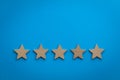 Five Star rating concept with wooden stars Royalty Free Stock Photo