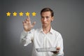 Five star rating or ranking, benchmarking concept. Man with tablet PC assesses service, hotel, restaurant Royalty Free Stock Photo