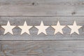 Five stars in a row on wooden planks, top rating concept