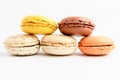 Five sweet French macarons with flavours of lemon, caramel, vanilla, coconut and chocolate, pastel colors of sweets isolated on wh