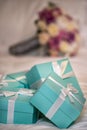 Five Teal Colored Gift Boxes with White Riibbon and Bows on a Bed Comforter Royalty Free Stock Photo