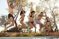 Five teenagers jumping into an outdoor swimming pool, Ibiza Royalty Free Stock Photo