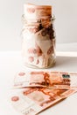 Five thousandth notes are packed in a glass jar. Russian banknotes with inscription `five thousand rubles` of 5000 rubles. Backgro Royalty Free Stock Photo