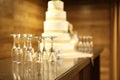 Five tiered wedding cake with empty champagne flutes on table Royalty Free Stock Photo