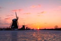 Traditional windmills with skater on ice Kinderdijk, Netherlands first sun at dawn Royalty Free Stock Photo