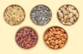 Five types of snacks in brown bowl: sunflower seeds, pumpkin seeds, peanuts, raisins, almonds. Above shot. Different samples