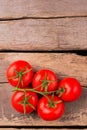 Five vine ripened tomatoes on wood.