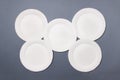 Five white eco-friendly plates lie on gray colored paper background. Top view. Mock-up Royalty Free Stock Photo