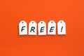 Five white wooden tags with the word FREE on a orange background Royalty Free Stock Photo