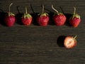 Five whole strawberries in a line at the top and one strawberry half at the bottom Royalty Free Stock Photo