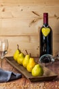 Five Williams pears on a wooden plate with wine glasses and seeds Royalty Free Stock Photo