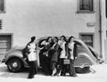 Five women standing in front of a car