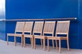 Five Wood Chairs by Blue Bulkhead Royalty Free Stock Photo