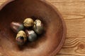 Five painted wooden eggs in antique wood bowl.