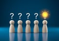 Five wooden figures with question marks and one lightbulb idea Royalty Free Stock Photo
