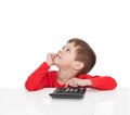 The five-year boy sitting at a white table and presses the button calculator Royalty Free Stock Photo