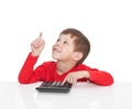 The five-year boy sitting at a white table and presses the button calculator Royalty Free Stock Photo