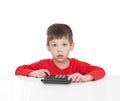 The five-year boy sitting at a white table and presses the button calculator Royalty Free Stock Photo