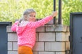 Five-year girl climbed on brick fence and turned around looked at the frame