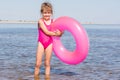 Five-year girl in pink bathing suit standing with swimming laps in the river Royalty Free Stock Photo