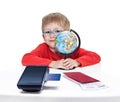 The five-year-old boy in blue points sits at a white table and holds the globe in hand Royalty Free Stock Photo