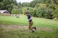 Five year old boy running outside on farm