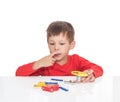 The five-year-old boy sits at a white table and plays an electronic designer Royalty Free Stock Photo