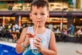 Five-year-old cute baby drinking juice from a tube Royalty Free Stock Photo