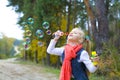 Five-year-old girl inflates soap bubbles