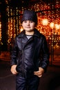 Five-year-old handsome boy in a black leather jacket bandana on the background of the night city Royalty Free Stock Photo