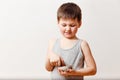 Five-year-old happy child in a gray t-shirt holding a sweet pancake and honey on a white background. Cook pancakes Royalty Free Stock Photo