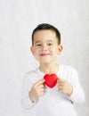 Five year old smiling boy holding a red heart figurine Royalty Free Stock Photo