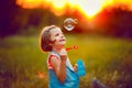 Five years old caucasian child girl blowing soap bubbles outdoor at sunset . Royalty Free Stock Photo