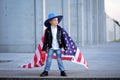 A portrait of modern, proude boy holding american flag.