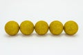 Five yellow Christmas baubles, lies in a row isolated on a white background with a clipping path and copy space, christmas decorat Royalty Free Stock Photo