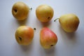 Five yellow orange pears on a white sunny table Royalty Free Stock Photo