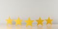 Five yellow wooden stars on table in row with selective focus on center star, five star review for best service or product quality