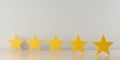 Five yellow wooden stars on table in row with selective focus, five star review for best service or product quality concept