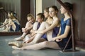 Five young dancers in the same dance costumes, resting sitting o Royalty Free Stock Photo