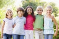 Five young friends standing outdoors smiling Royalty Free Stock Photo