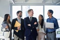 Five young happy professional team business people standing in office laughing. Royalty Free Stock Photo