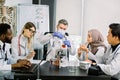 Five young multiethnic doctors scientists, bioengeneers, chemists, working in modern laboratory center. Male scientist