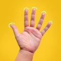 Fiver finger hand isolated on yellow background Royalty Free Stock Photo